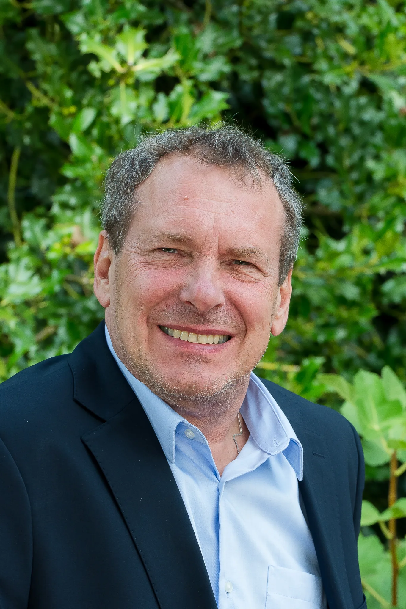 Detlev Berger lacht, im Hintergrund eine Hecke